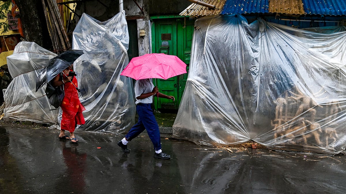 Unfinished Durga idols covered in plastic sheets amid rain ahead of Durga Puja in Kolkata.