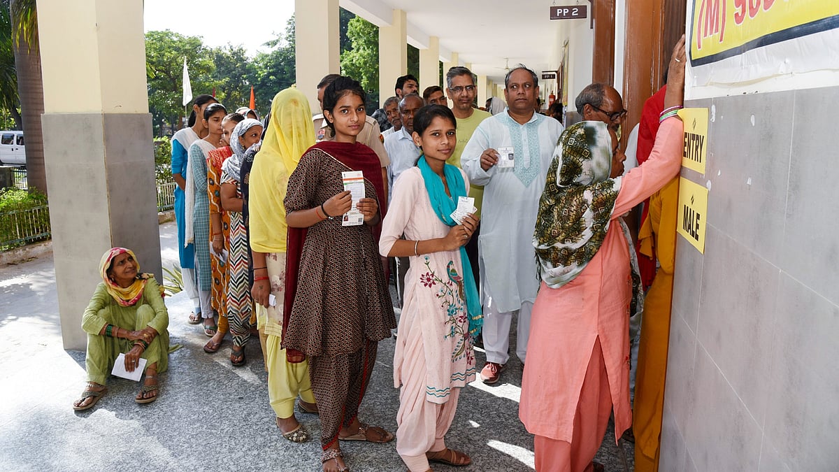 Young voters queue at a polling station in Haryana.