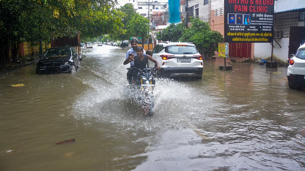 Vehicles move through a waterlogged road in Lucknow.