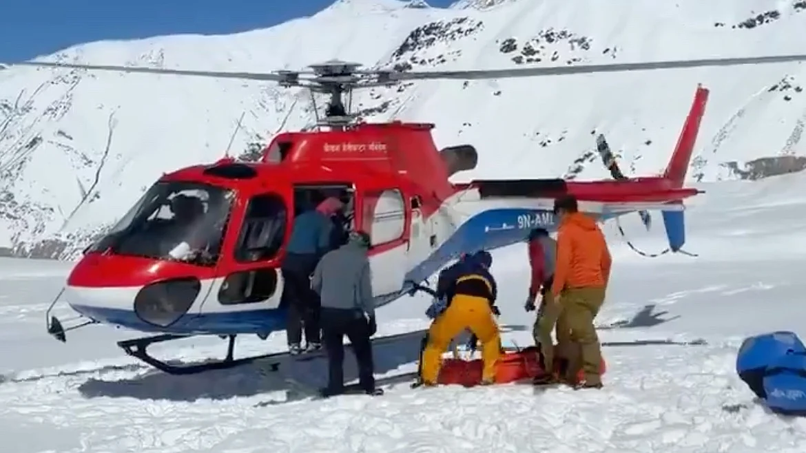 Rescuers load one of the dead into a helicopter
