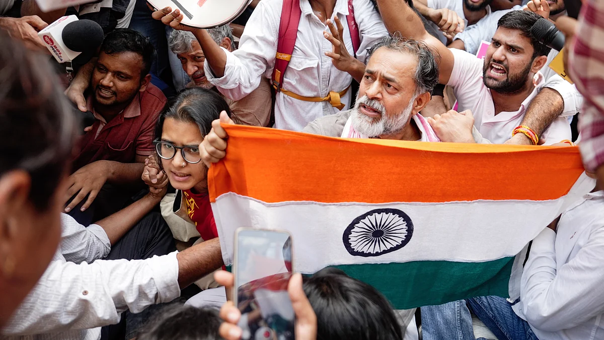 Yogendra Yadav (with flag), Neha Bora (L), and others at the Jantar Mantar protest against Gyanesh Kumar
