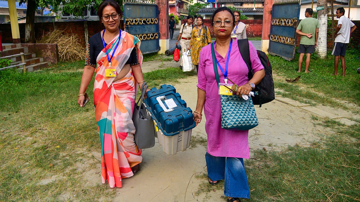 Polling officials carry EVMs and election materials ahead of the Nagaon bypoll.