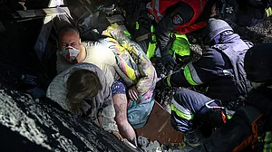 Rescuers pull a family from a building destroyed by a Russian airstrike in Zaporizhzhia, Ukraine, 10 Oct
