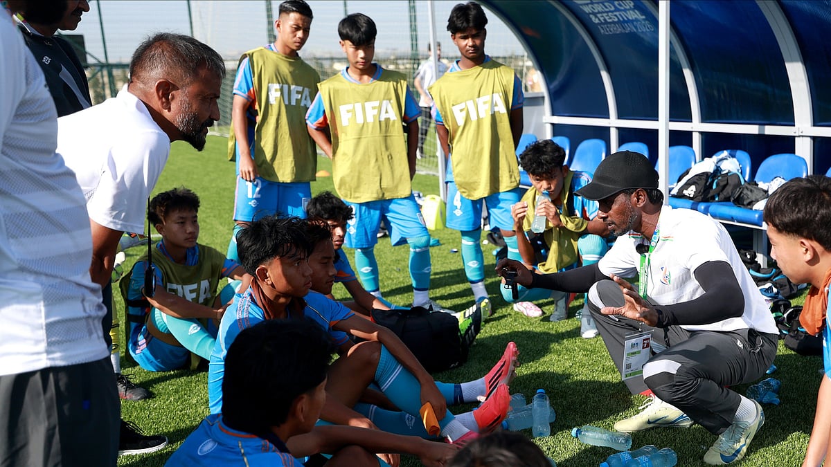Bibiano Fernandes (with black cap) talks strategy with his boys during a break