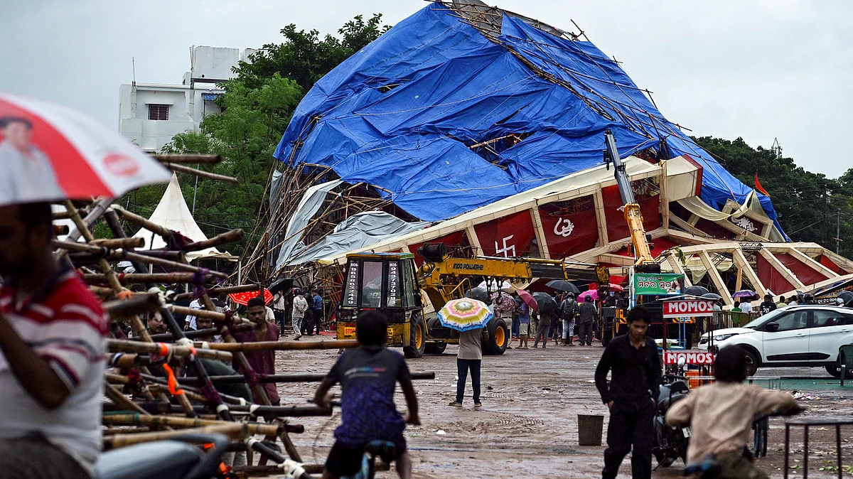 Workers clear debris after a pandal collapses amid Cyclone Arnab in Bhubaneswar.