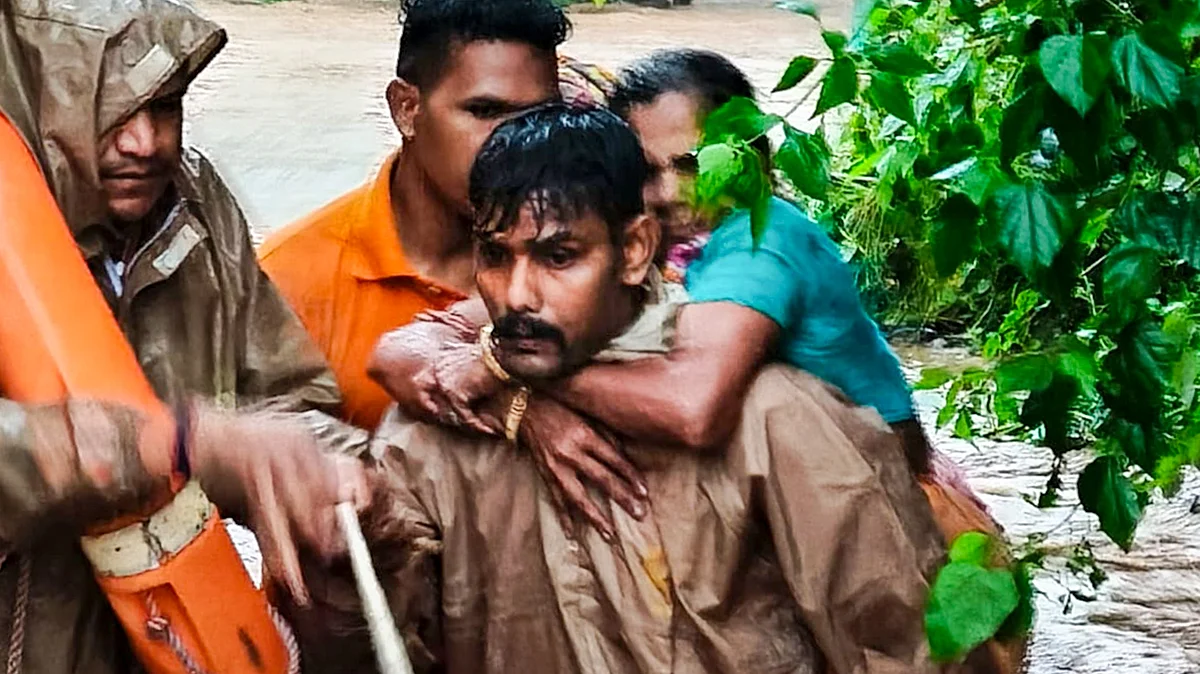Fire personnel rescue a woman stranded at Budhi Thakurani Temple in Bhanjanagar.