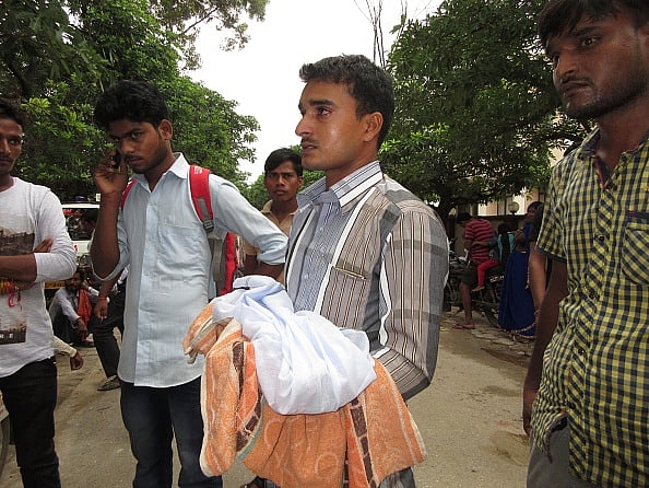गोरखपुर के बीआरडी अस्पताल में मासूम का शव ले जाते परिजन / फोटो : Getty Images