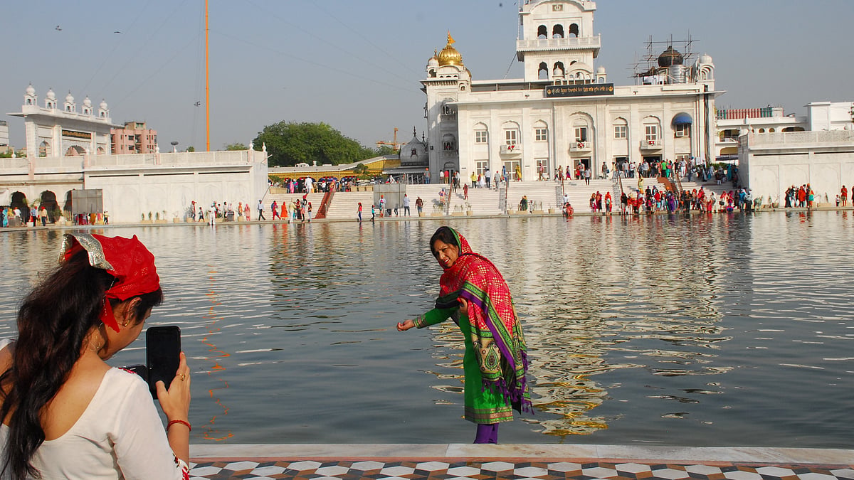 

दिल्ली के बंगला साहिब गुरुद्वारा में बैसाखी पर फोटो खिंचवाती एक महिला