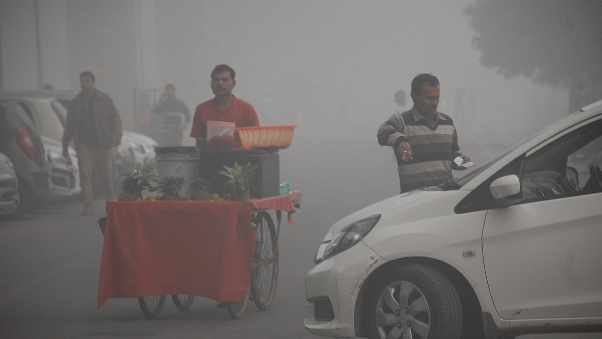 मौसम की परवाह किए बगैर गाजियाबाद के कौशांबी में एक ठेले वाला अपने रोजाना के काम पर