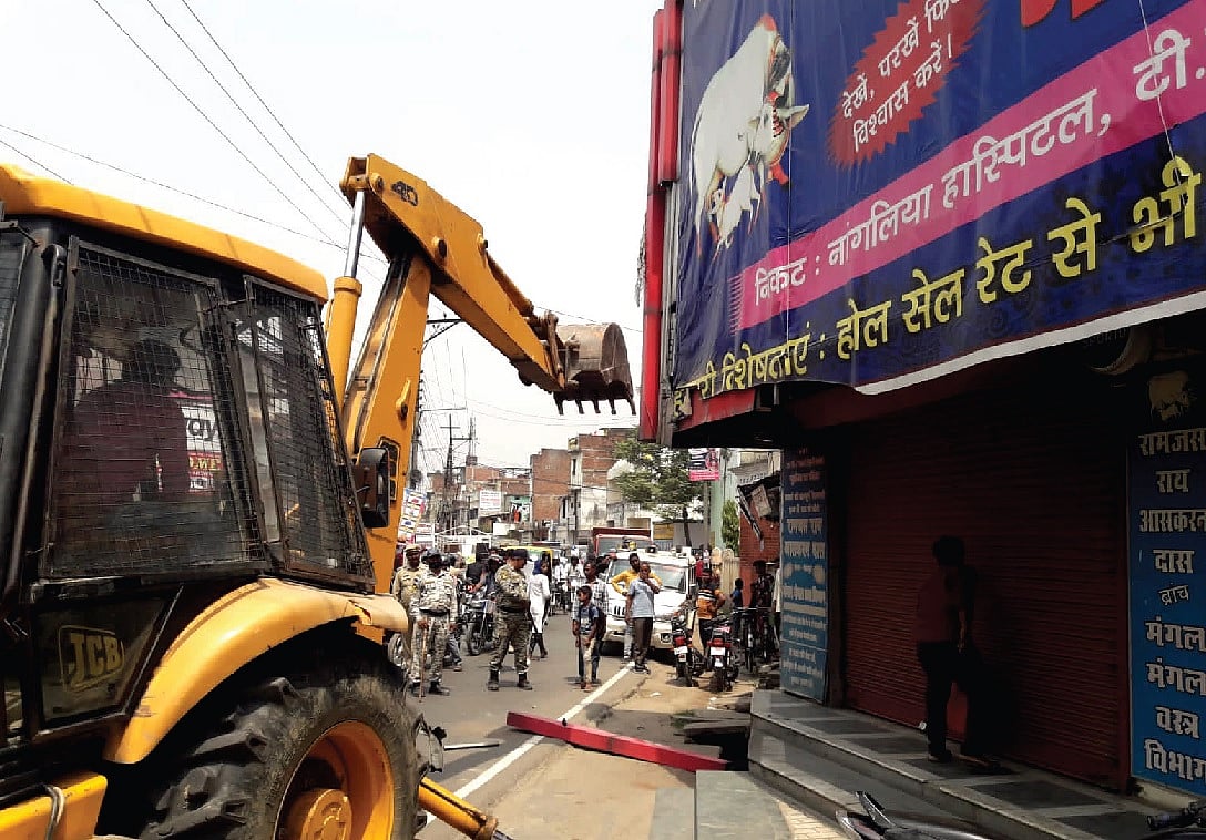 गोरखपुर में अतिक्रमण विरोधी अभियान के दौरान पुलिस ने एक व्यापारी को पकड़ लिया। जहां कार्रवाई
हो रही थी, वह दुकान बड़े कपड़ा कारोबारी शम्भु शाह के परिवार की है। शम्भु शाह ने ही योगी आदित्यनाथ के दोबारा मुख्यमंत्री बनने के बाद गोरखनाथ मंदिर पहुंचकर चांदी का बुलडोजर गिफ्ट किया था।