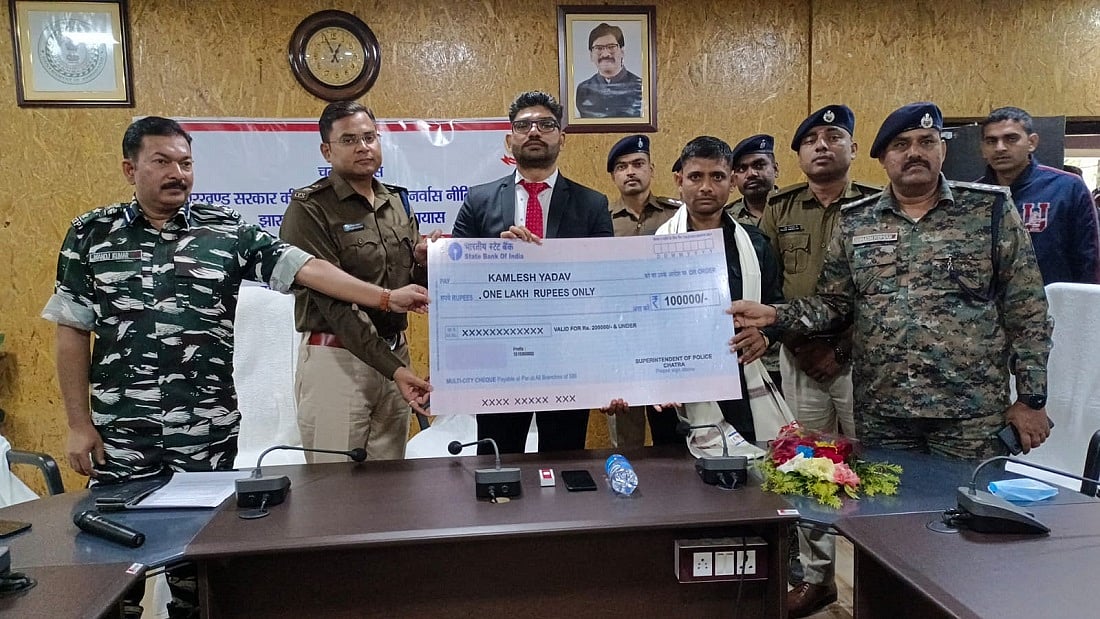 चतरा में पुलिस अधिकारियों के समक्ष सरेंडर के बाद चेक लेता नक्सली कमांडर कमलेश