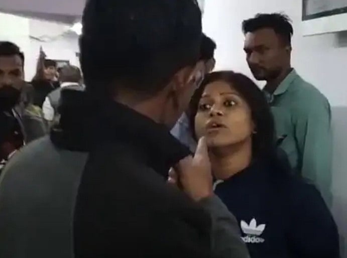 पुलिस से बहस करती आरोपियों के घर की महिला