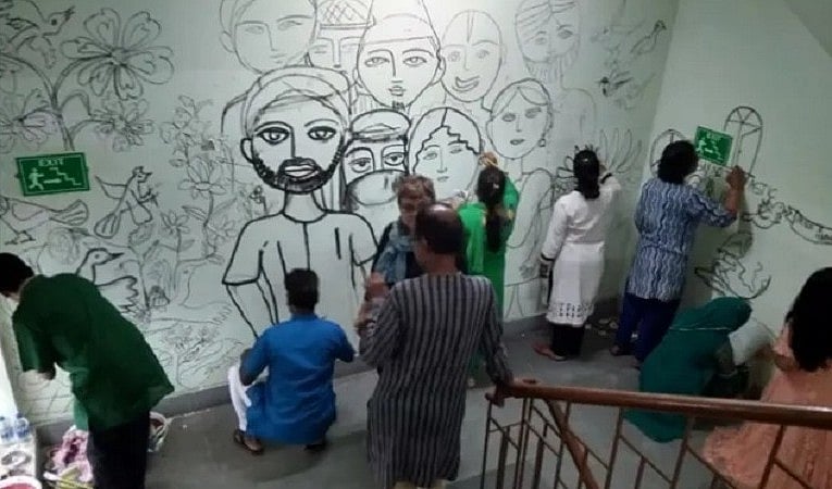एकता की दीवार पर चित्रकारी करते आर्टिस्ट (तस्वीर कोलकाता की है)