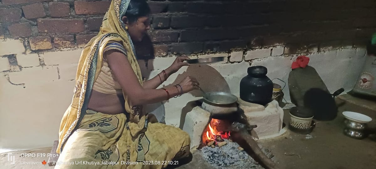 छिंदवाड़ा जिले के खूटिया गांव की सरूपवती आदिवासी, घर में लकड़ी वाले चूल्हे पर खाना पकाती हुई।