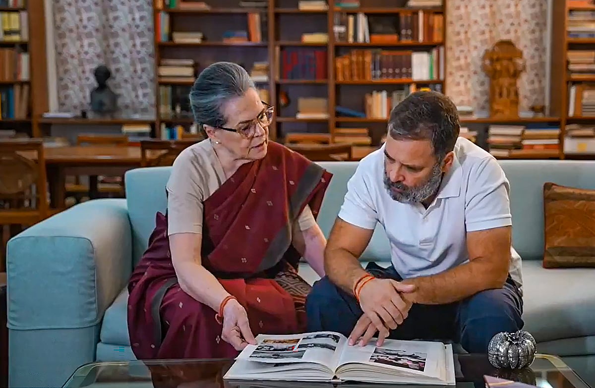 राहुल गांधी अपनी मां और कांग्रेस की पूर्व अध्यक्ष सोनिया गांधी के साथ परिवार के अमेठी से जुड़ाव की फोटो अल्बम देखते हुए (फोटो - पीटीआई)