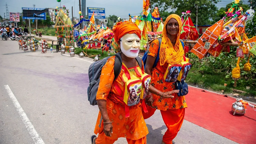 उत्तर प्रदेश में पीएम मोदी का मुखौटा पहने एक कांवड़ यात्री (फोटो : Getty Images)