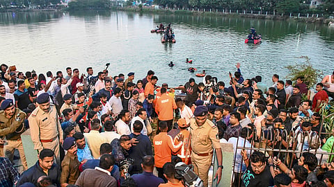 People gather during a rescue and search operation after a boat overturned in a lake, in Vadodara on Thursday