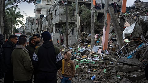 Palestinians look at the destruction after an Israeli strike in Rafah, southern Gaza Strip. 
