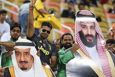 Saudi fans hold pictures of King Salman, left, and Crown Prince Mohammed bin Salman ahead of the Italian Super Cup final soccer match between AC Milan and Juventus at King Abdullah stadium in Jiddah, Jan. 16, 2019. 
