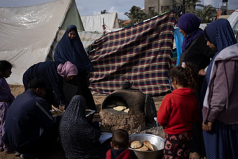 Palestinians displaced by the Israeli ground offensive on the Gaza Strip cook at the makeshift tent camp in Rafah on Tuesday, Jan. 23, 2024.