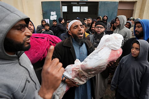 Palestinians chant Islamic slogans while carry the bodies of children killed in the Israeli strikes in the Gaza Strip in front of the morgue at Al Aqsa hospital in Deir al Balah, Gaza Strip. 