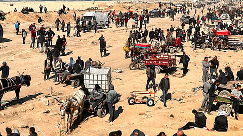 Palestinians wait for humanitarian aid on a beachfront in Gaza City, Gaza Strip.