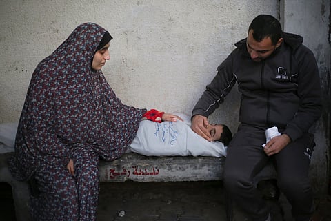 Palestinians mourn a child killed in the Israeli bombardment of the Gaza Strip at a hospital morgue in Rafah, Monday, Feb. 12, 2024. 