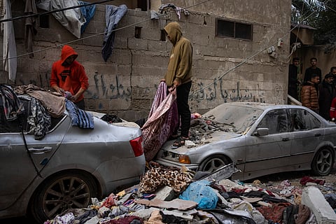 Palestinians look at the destruction after an Israeli airstrike in Rafah, Gaza Strip, Friday, Feb. 9, 2024. 
