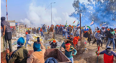 Farmers look for cover after police fired tear gas at them during their 'Delhi Chalo' march, near the Punjab-Haryana Shambhu border, in Patiala district, Wednesday, Feb. 21, 2024.