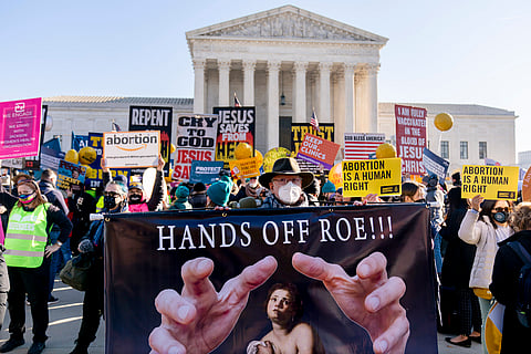 Stephen Parlato of Boulder, Colo., holds a sign that reads "Hands Off Roe!!!" as abortion rights advocates and anti-abortion protesters demonstrate in front of the U.S. Supreme Court, Wednesday, Dec. 1, 2021, in Washington. 