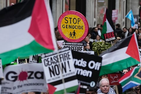 Pro-Palestinian protesters hold up placards during a demonstration in London, Saturday, Feb. 3, 2024 as they demand for a full cease fire and an end to the siege of Gaza. 