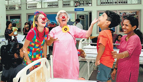 Two clowns showed up unannounced. Dressed in colours that were a direct contrast to the dull, grey walls.