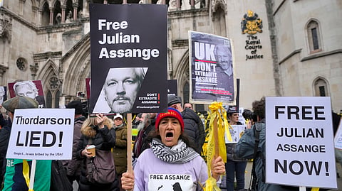 Demonstrators hold banners outside the Royal Courts of Justice in London, Tuesday, Feb. 20, 2024. 