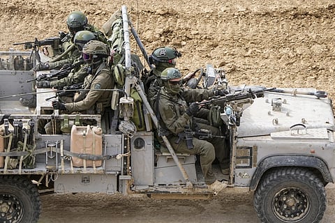Israeli soldiers drive towards the Gaza Strip, in Southern Israel, Tuesday, Feb 13, 2024. 
