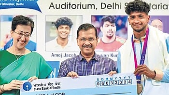 Delhi Chief Minister Arvind Kejriwal presents a cheque of Rs 1 crore to 19th Asian Games gold medalist athlete Amoj Jacob during a felicitation programme on March 6, 2024. Delhi Minister Atishi Singh is also seen.