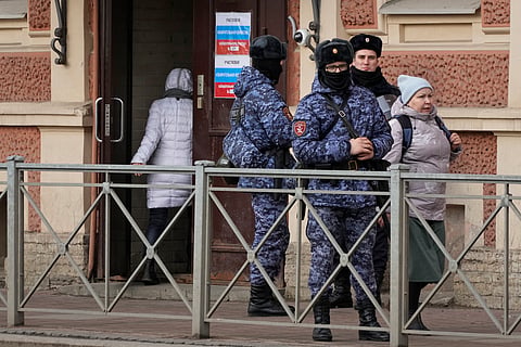 Russian Rosguardia (National Guard) servicemen stand guard at a pooling station during the presidential elections in St. Petersburg, Russia, Saturday, March 16, 2024. 