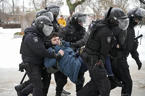 Police detain a man trying to lay flowers to honour Alexei Navalny at a monument in St Petersburg, Russia, to victims of Soviet repression, on Saturday, Feb 17, 2024. 