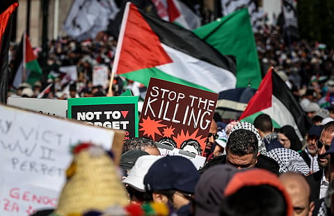 Protesters lift placards and flags of Palestine during a demonstration in Rabat on February 11, 2024 in solidarity with Palestinians amid Israel's ongoing bombardment of the Gaza Strip. 