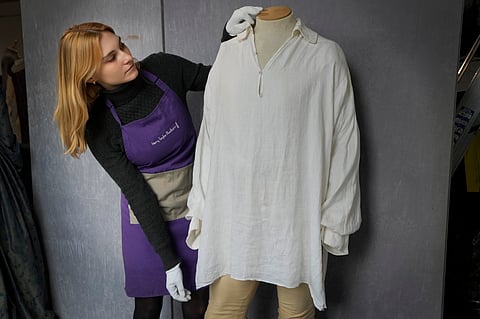 A costume handler arranges Colin Firth's 'wet-shirt' costume