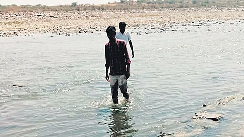 Mudimanikyam residents were seen crossing the Krishna River to reach Gottimukkala village in Andhra Pradesh by foot on Thursday