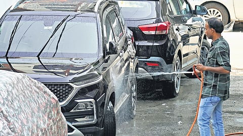 A resident of JC Nagar, near Jayamahal Road washes cars, while the city is gripped by a water crisis. 