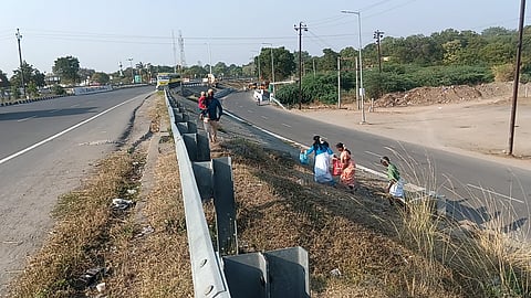 Passengers dropped off on the highway climbing over the barricadin