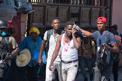 An injured journalist is helped after he was reportedly hit by a tear gas canister fired by police in Port-au-Prince, Haiti, on March 9, 2024. Sporadic gunfire rang out in Port-au-Prince late March 8, an AFP correspondent there heard, as residents desperately sought shelter amid the recent explosion of gang violence in the Haitian capital. 