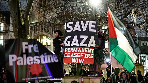 Pro-Palestinian demonstrators wave Palestinian flags and hold placards as they protest in Parliament Square in London on February 21, 2024, during an Opposition Day motion in the the House of Commons calling for an immediate ceasefire in Gaza.