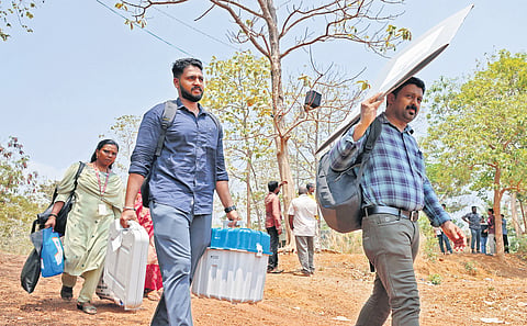 Officials carry electronic voting machines and other polling equipment from S N College, Varkala, Thiruvananthapuram, on Thursday, to their respective polling booths 