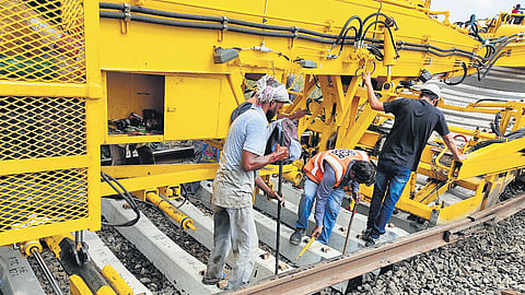 Workers replacing concrete sleepers under railway tracks in Vijayawada