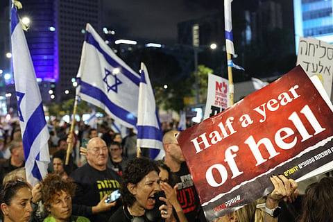 Relatives and supporters of Israeli hostages held in Gaza since the October 7 attacks by Hamas militants hold placards and wave Israeli flags during a demonstration in front of the Defence Ministry in the Israeli coastal city of Tel Aviv, on April 6, 2024