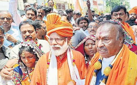 Independent candidate for Shivamogga Lok Sabha constituency KS Eshwarappa arrives to file his nomination with PM Modi lookalike Sadananda Nayak of Udupi, on Friday. 