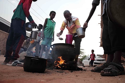 People prepare food in a Khrtoum neighborhood in Sudan on June 16, 2023. 
