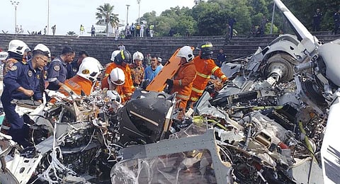 In this photo released by Fire & Rescue Department of Malaysia, fire and rescue department inspect the crash site of two helicopter in Lumur, Perak state, Monday, April 23, 2024. 